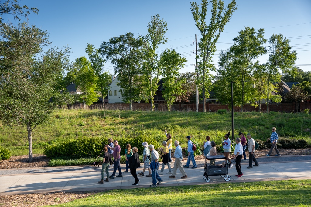 Participants exploring habitat on a nature walk at Moncus Park