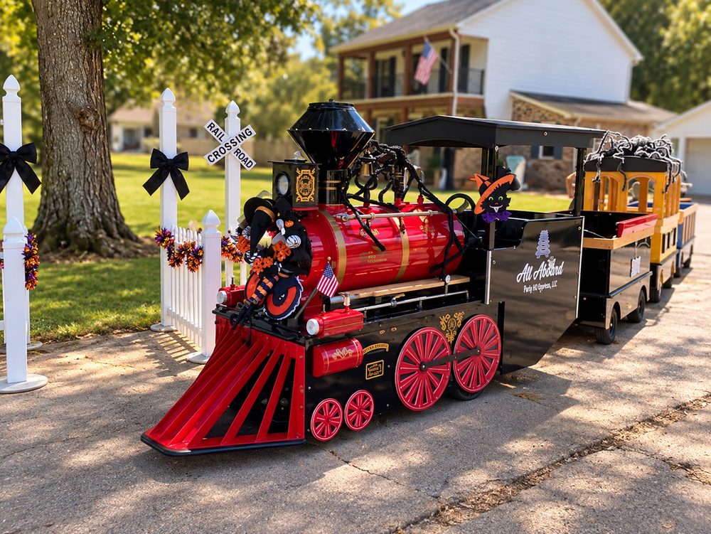 The Boo Train, a red and black ride-on train decorated for Halloween with witches, a black cat, and spiders, from All Aboard Party Headquarters