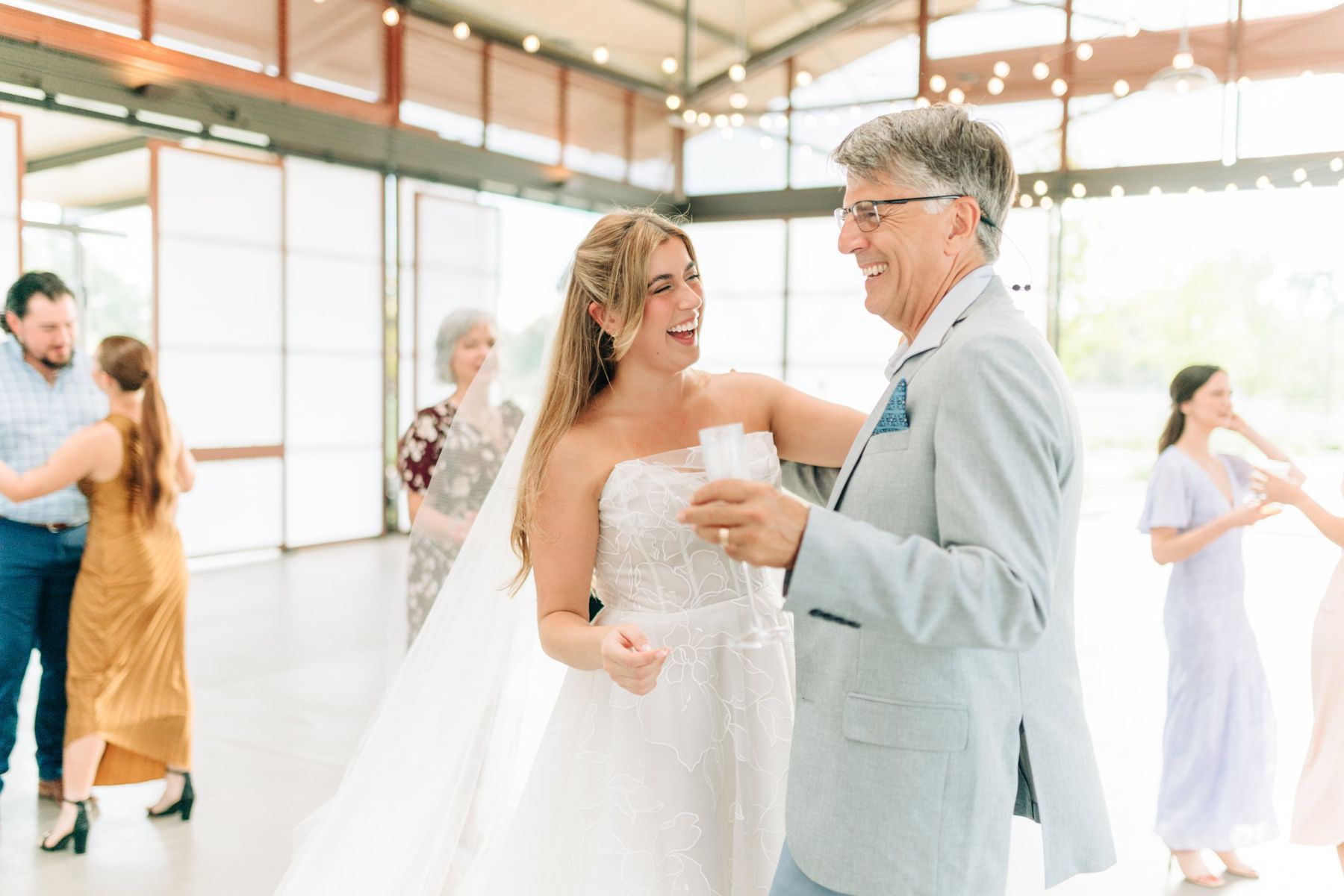 Moncus Park: bride laughing while dancing with a guest inside the Doerle Pavilion