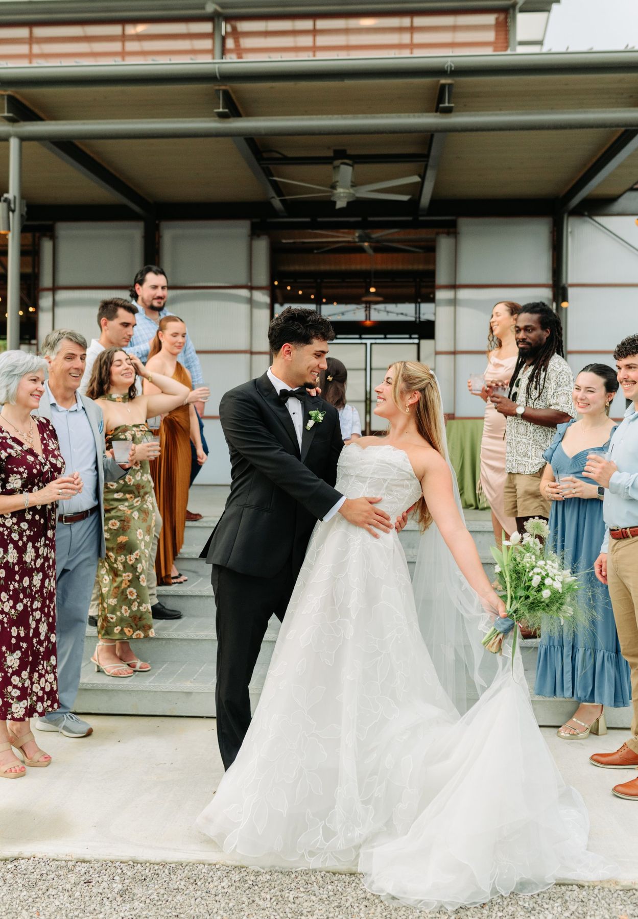 Moncus Park: groom dipping the bride as guests cheer with drinks outside the Doerle Pavilion