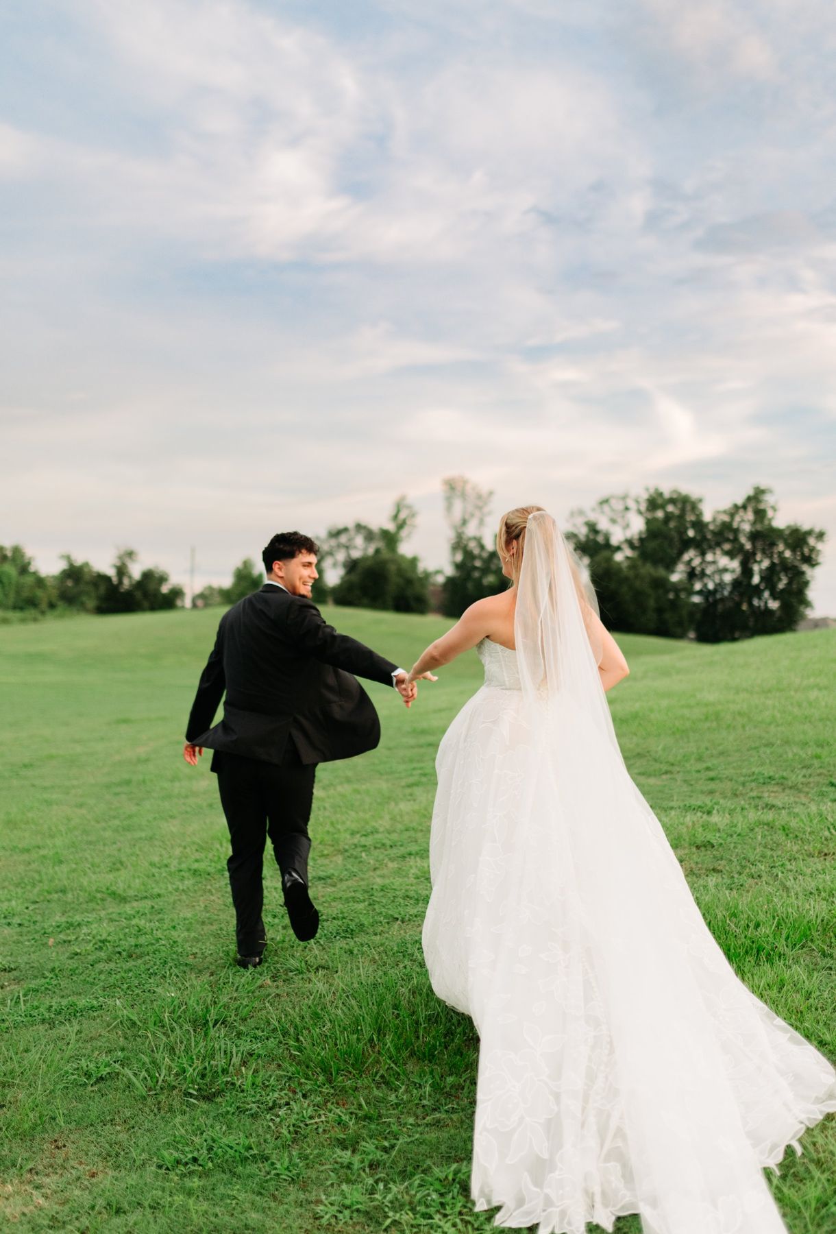 Moncus Park: couple running hand in hand up a grassy hill